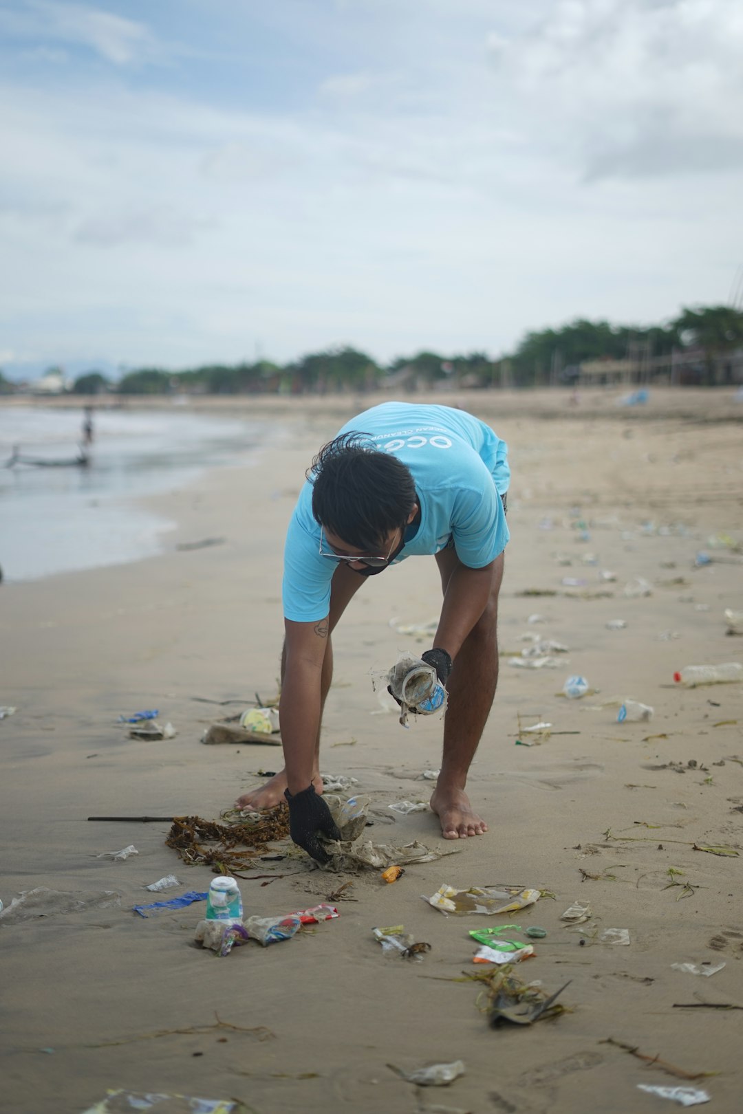 picking up plastic on the beach